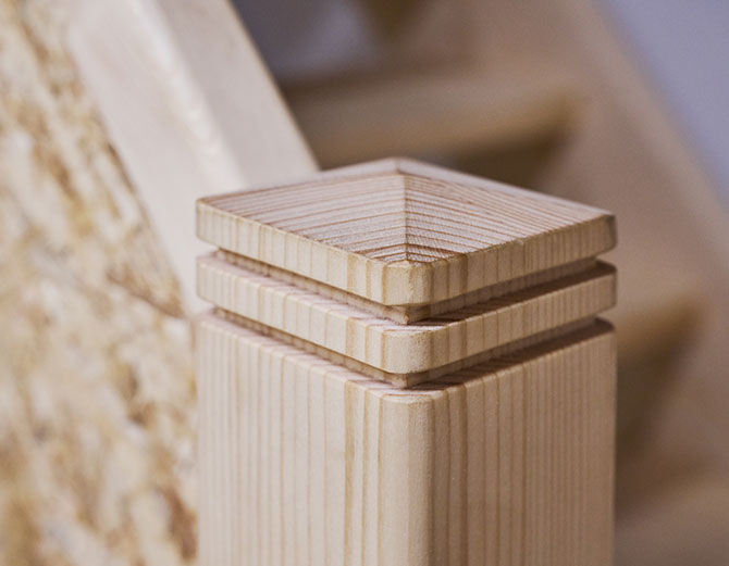 Detailaufnahme eines handgefertigten Holzpfostens